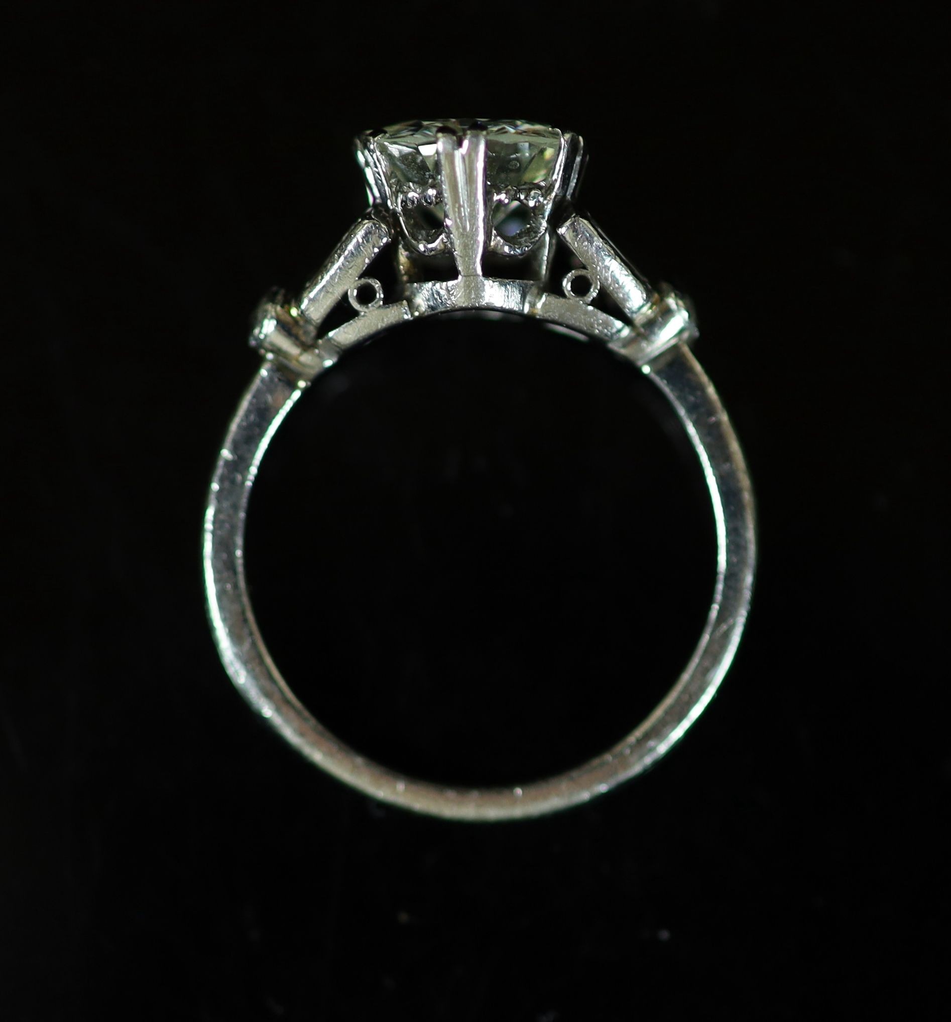 A platinum and single stone diamond ring, with baguette and diamond chip set shoulders